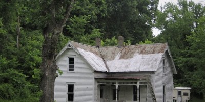 old house with lots of weathering in rural setting