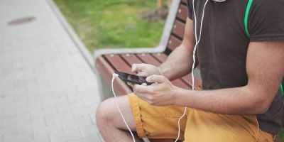 Image of a man using his smartphone to find music online.