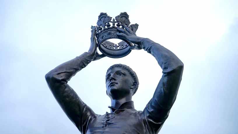 statue of king putting on his crown