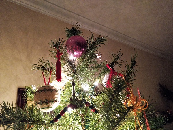 a decorated Christmas tree topped with a purple ball ornament