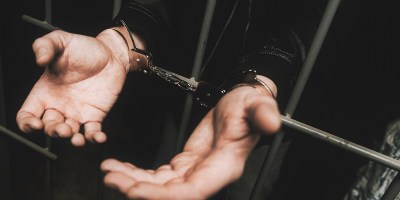 hands held out through prison bars