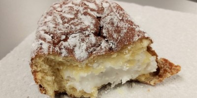 a half-eaten paczki filled with frosting