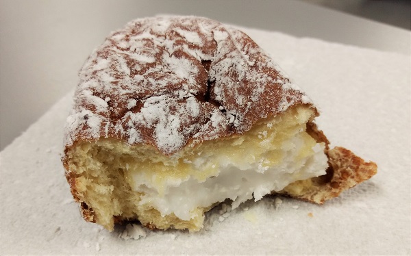 a half-eaten paczki filled with frosting