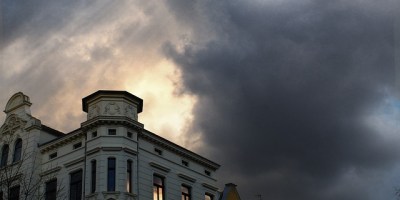 storm clouds over a row of concrete buildings