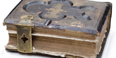 Shearer family illustrated bible with leather hardcover binding, and ornate metallic recessed design with metal clasp enclosures