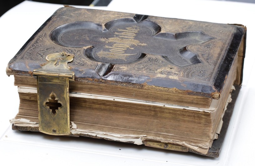 Shearer family illustrated bible with leather hardcover binding, and ornate metallic recessed design with metal clasp enclosures