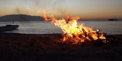 Image of a fire on a beach at dusk