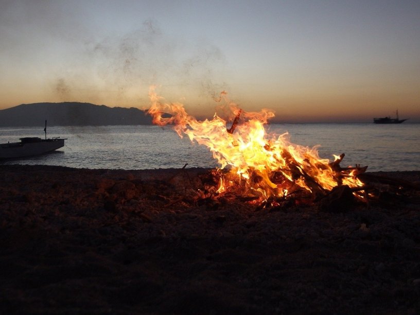 Image of a fire on a beach at dusk
