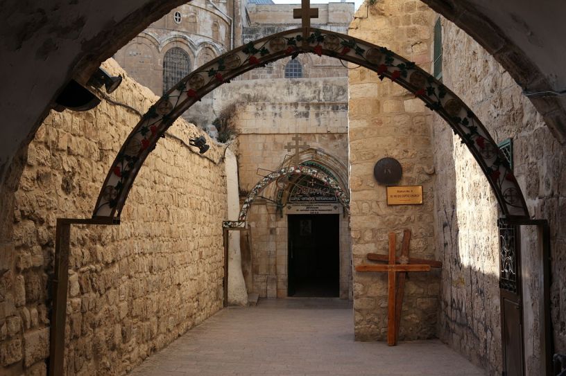 A view of an entrance to the Coptic Orthodox Patriarchate in Jerusalem, with arches topped with crosses on the pathway