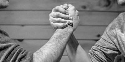 Two men's hands grip in an arm wrestling match