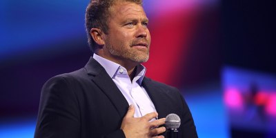 Tim Ballard standing with a microphone.