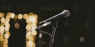 profile shot of a microphone mounted in a stand with out-of-focus golden lights in the background